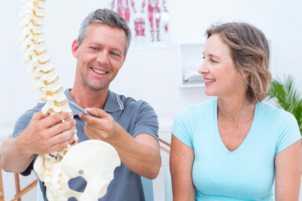 A doctor showing a patient a model of a spine